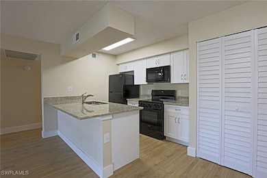 Kitchen featuring a peninsula, visible vents, a si