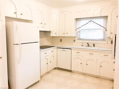 Bright, white kitchen with freshly painted cabinets and new hardware