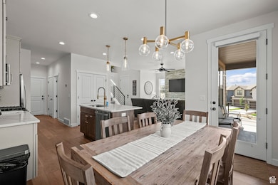 Dining room featuring a chandelier, recessed lighting, dark wood finished floors, ceiling fan, and a stone fireplace