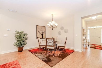 Dining space with wood finished floors, a chandelier, and baseboards