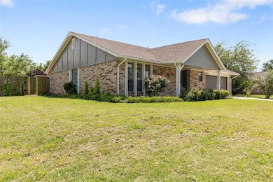View of front of home with a garage, brick siding, board and batten siding, and a shingled roof
