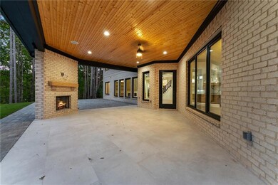 View of patio / terrace featuring an outdoor brick fireplace and an attached carport