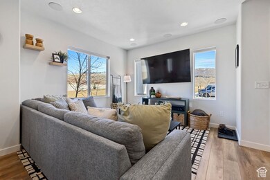Living room featuring a wealth of natural light, recessed lighting, baseboards, and wood finished floors