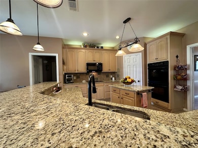 Kitchen with tasteful backsplash, a sink, light st