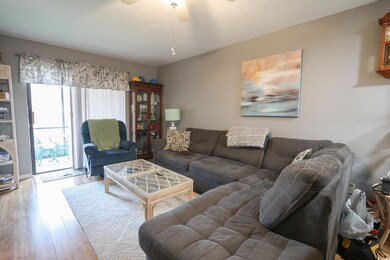 Living area featuring a ceiling fan and wood finis