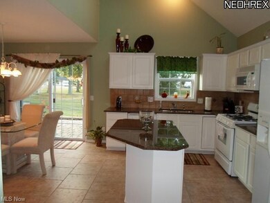 Kitchen features large floor tiles and granite cou