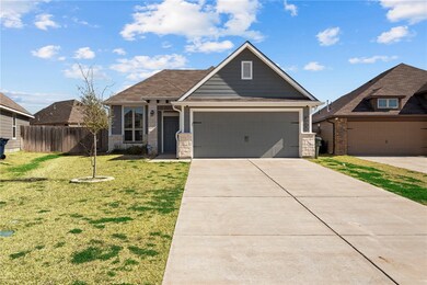 View of front facade with a garage and a front law