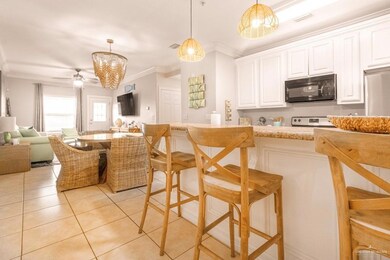 Kitchen featuring ornamental molding, open floor plan, black microwave, stove, and hanging light fixtures