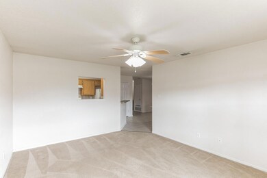 Empty room with ceiling fan and light carpet