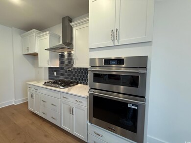 Kitchen with decorative backsplash, light stone co
