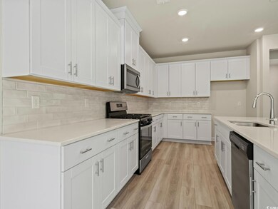 Kitchen with sink, white cabinets, stainless steel
