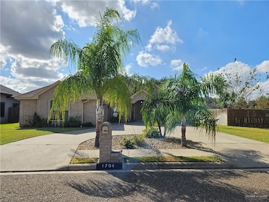 Obstructed view of property with curved driveway and brick siding