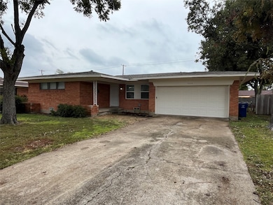 Ranch-style house with brick siding, concrete driveway, a front lawn, and a garage