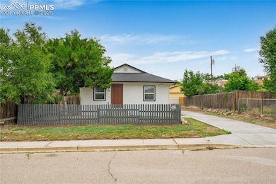 View of front of home with stucco siding, a fenced front yard, roof with shingles, and driveway
