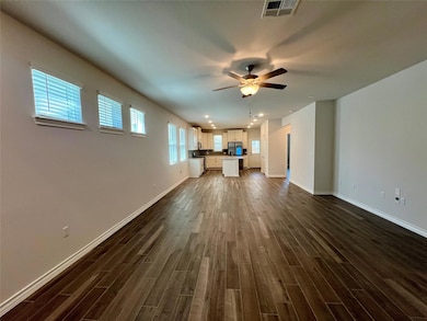 Unfurnished living room featuring dark wood-type flooring, a ceiling fan, and recessed lighting