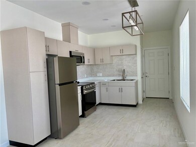 Kitchen featuring appliances with stainless steel finishes, light countertops, decorative backsplash, and plenty of natural light