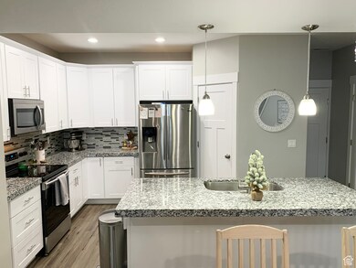 Kitchen with appliances with stainless steel finishes, decorative backsplash, light stone countertops, and recessed lighting
