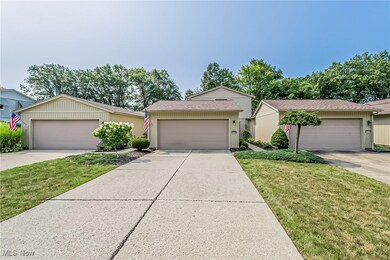 Single story home with a garage and a front lawn