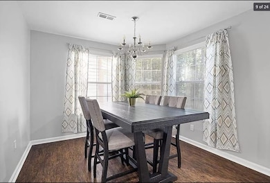 Dining room with dark wood-style flooring, a notab