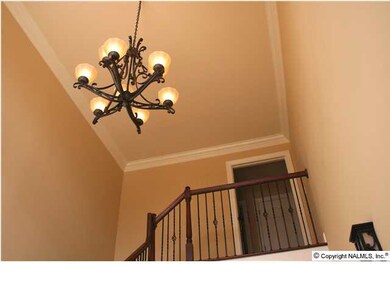 The decorative chandelier, crown moulding, wrought iron staircase spindles, & radius window give this home a custom look & feel