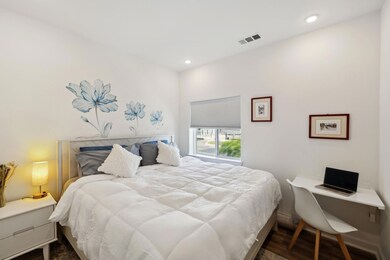 Bedroom with dark wood-style flooring and recesse