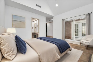 Lofty ceilings and large windows transform your primary bedroom into a light-filled oasis, offering a peaceful start to each day. Note the sliding doors leading to your outdoor area and front yard