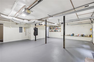 Garage with electric panel and a garage door opener