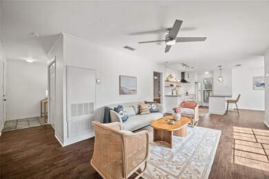 Living area featuring dark wood-style flooring and a ceiling fan