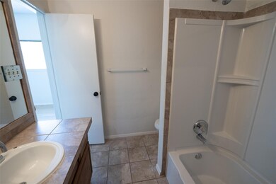 Full bath featuring vanity, baseboards, tile patt