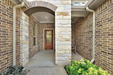 View of exterior entry with brick siding