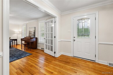 Foyer featuring crown molding and light wood-style