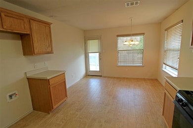 Kitchen with light wood-type flooring, a chandeli