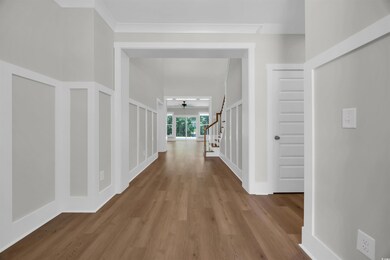 Hallway with wood finished floors and stairs