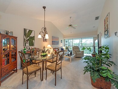 Dining space with lofted ceiling, light carpet, an