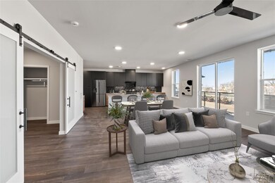 Living room with a barn door, ceiling fan, recess