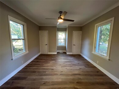 Unfurnished bedroom featuring dark hardwood / wood-style flooring, multiple windows, and ceiling fan