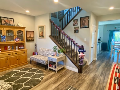 Stairs featuring wood finished floors and recessed lighting