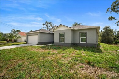 Ranch-style house featuring driveway, stucco siding, an attached garage, and a front lawn