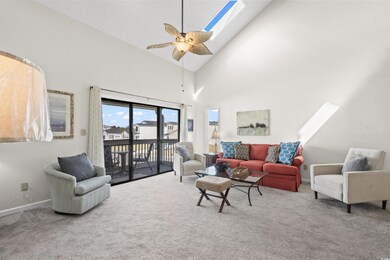 Carpeted living room with high vaulted ceiling, a 