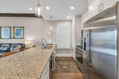 Kitchen with dark wood-style flooring, stainless s