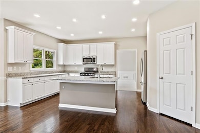Kitchen featuring appliances with stainless steel finishes, a sink, white cabinetry, and recessed lighting