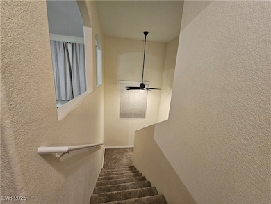 Staircase with a textured wall, carpet, baseboards