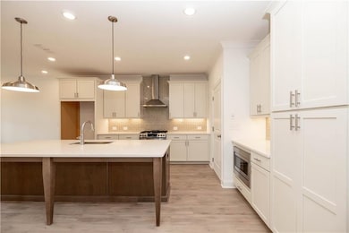 The Warm Wheat Design Collection offers Vanilla perimeter cabinets with a latte stained island, creamy quartz countertops & built in panty concept.  Pictures represent a previously built home, not the actual home.