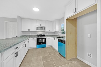 A sparkling kitchen boasts white cabinets with sophisticated black hardware. Enjoy preparing meals on sizable granite-topped counters that surround new stainless steel appliances.