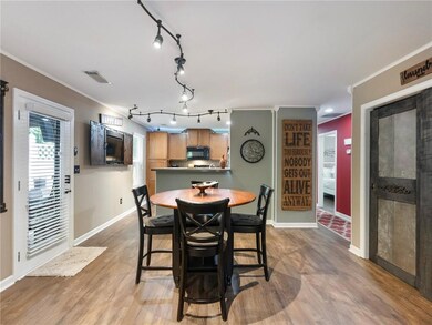 Dining room with baseboards, track lighting, light wood-type flooring, and crown molding