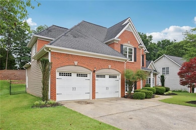 View of front facade featuring driveway, an attached garage, and brick siding