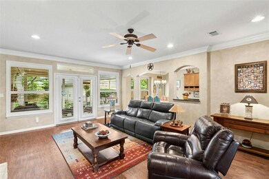Living area featuring arched walkways, ceiling fa