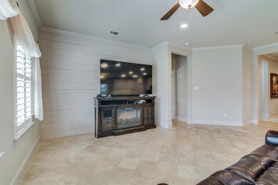 Living room featuring ornamental molding, window, and ceiling fan