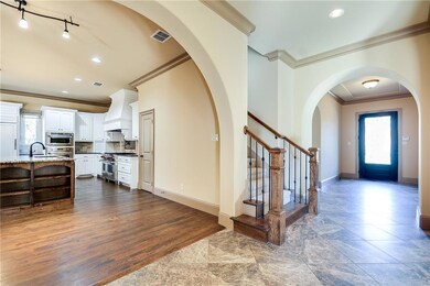 A tile foyer leads to stairs, and to the kitchen-b