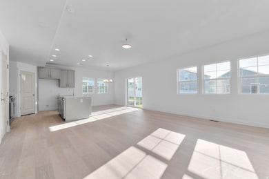 Unfurnished living room with recessed lighting, light wood-style floors, and a chandelier